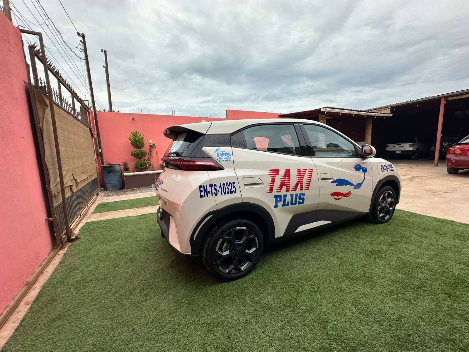 Unidad blanca de Taxi Plus Ensenada, identificada con el logotipo de la central